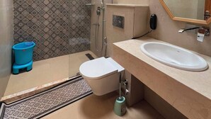 A compact bathroom with a shower, toilet, and sink.