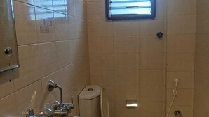 Un baño con lavamanos, inodoro y ducha.