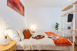 A bedroom with a bed, bedside table, lamp, and a wall-mounted artwork. - New Town Boutique apartment with Free Parking (Prague)