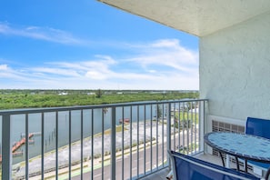 Ein Balkon mit Blick auf einen Fluss, einen Parkplatz und eine entfernte Landschaft.