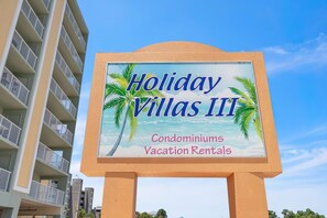 A sign for Holiday Villas III, indicating it offers condominiums and vacation rentals.