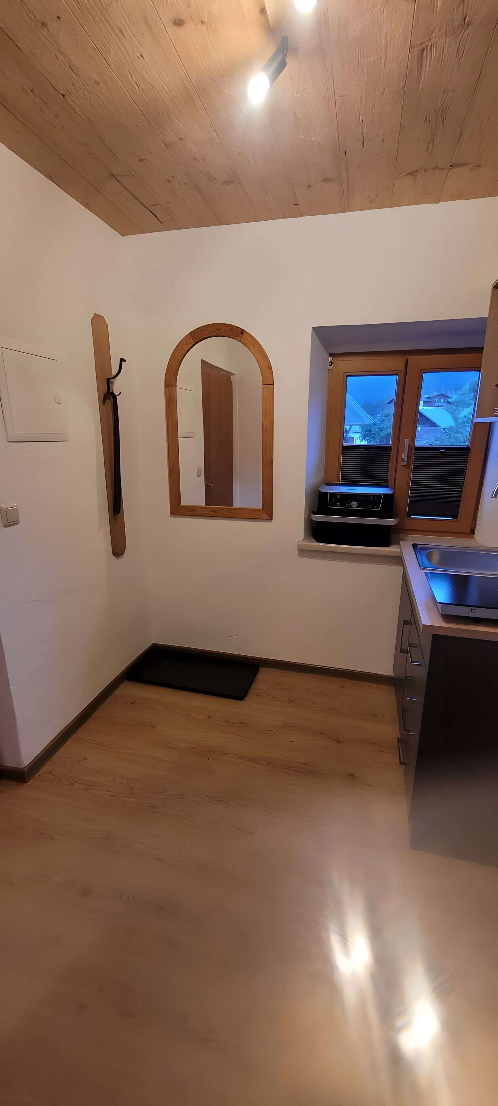 Una cocina con armarios de madera, estufa empotrada y ventana con vistas.