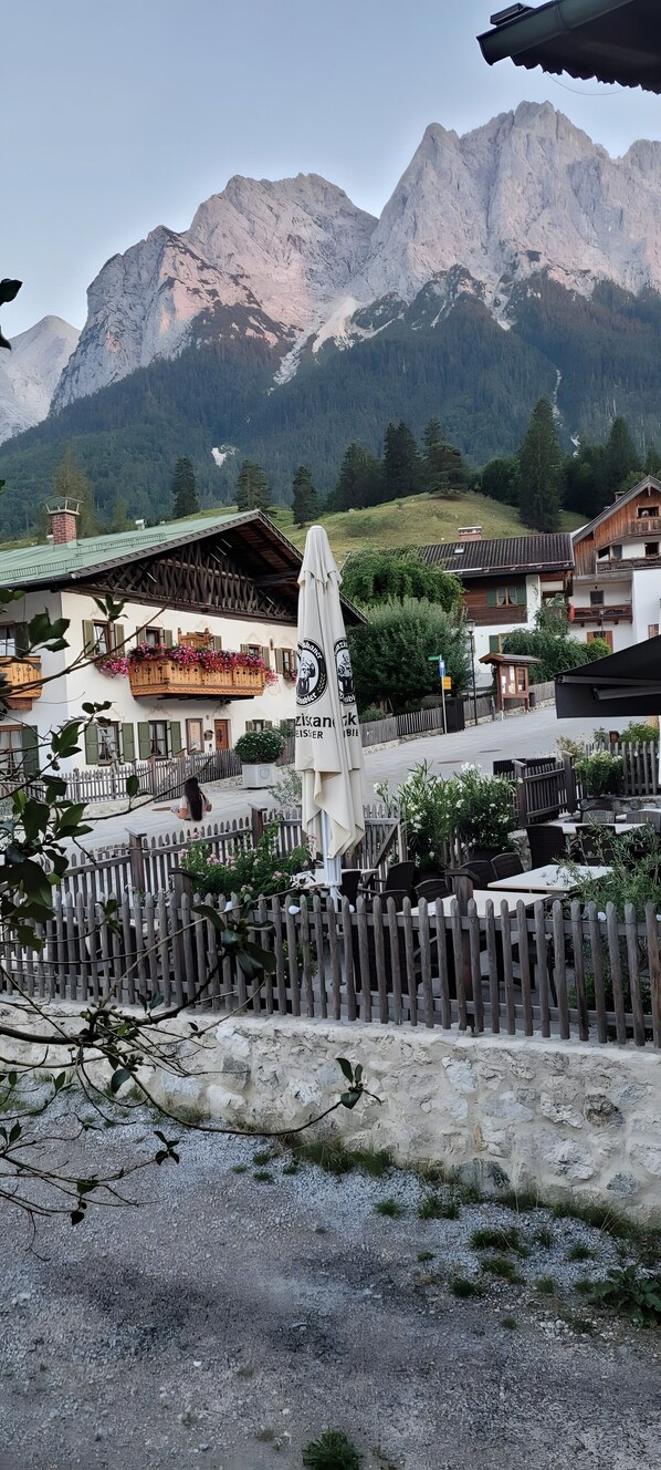 A mountain view with a wooden fence and a building with a balcony.