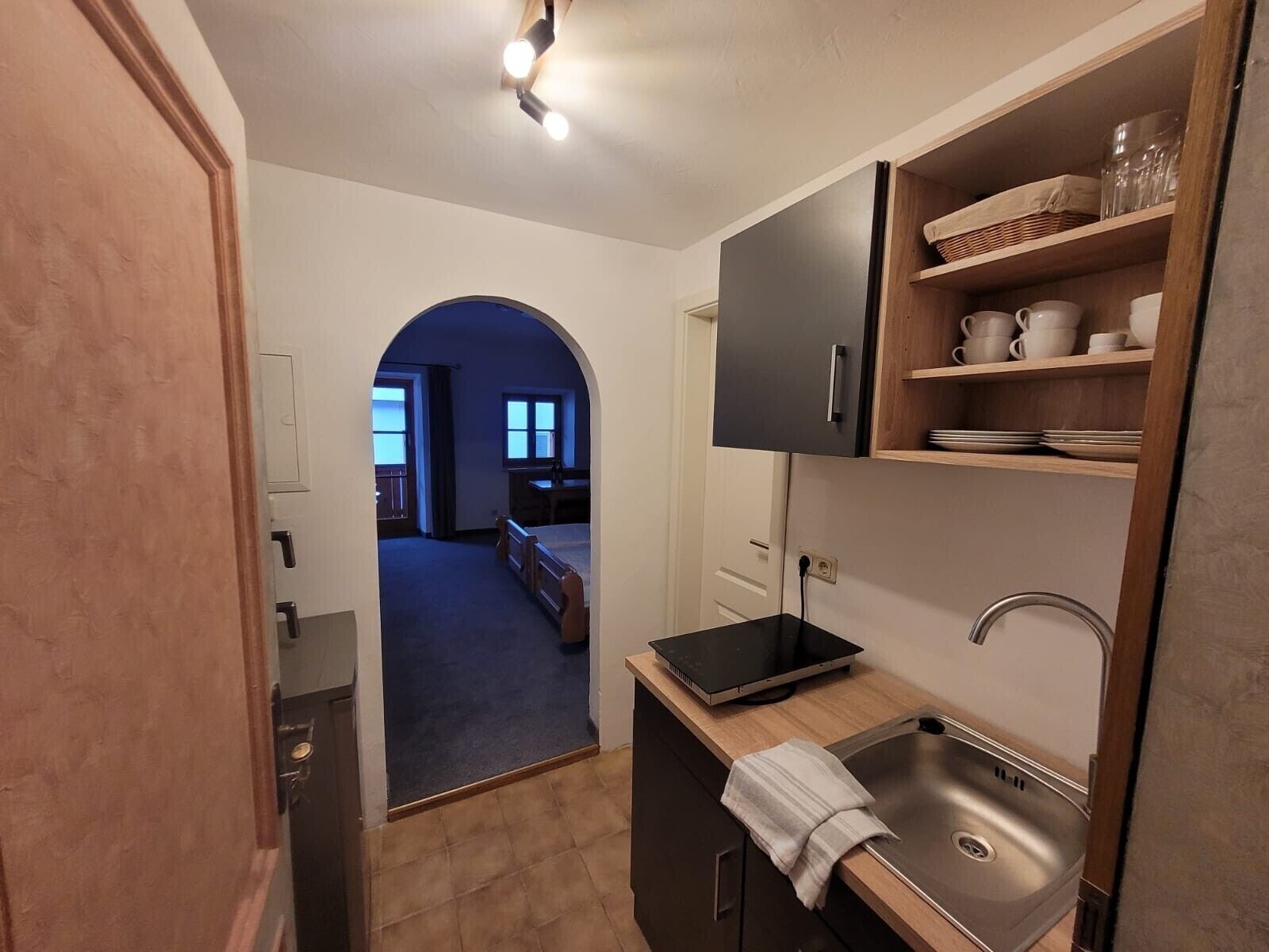Una cocina compacta con horno integrado, un lavamanos y una encimera.