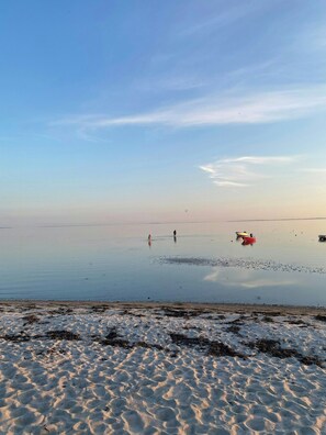 A beach with calm water, a few boats, and footprints in the sand. - Holiday home with enchanting garden in Kulhuse (Jægerspris)