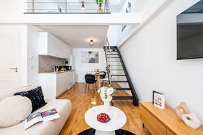 A modern apartment with a kitchen, dining area, and a staircase leading to an upper level. - New Town City Loft with Free Parking (Prague)