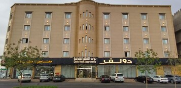 Un hotel de varios pisos con una entrada central y varios balcones.