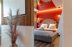 Un dormitorio moderno con cama, un diseño decorativo en la pared y un florero con plantas secas.