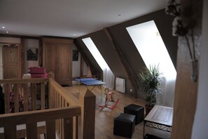 A loft-style room with a wooden staircase, a ping pong table, and a rocking horse. - Large, charming vacation rental for 15 people (Barentin)