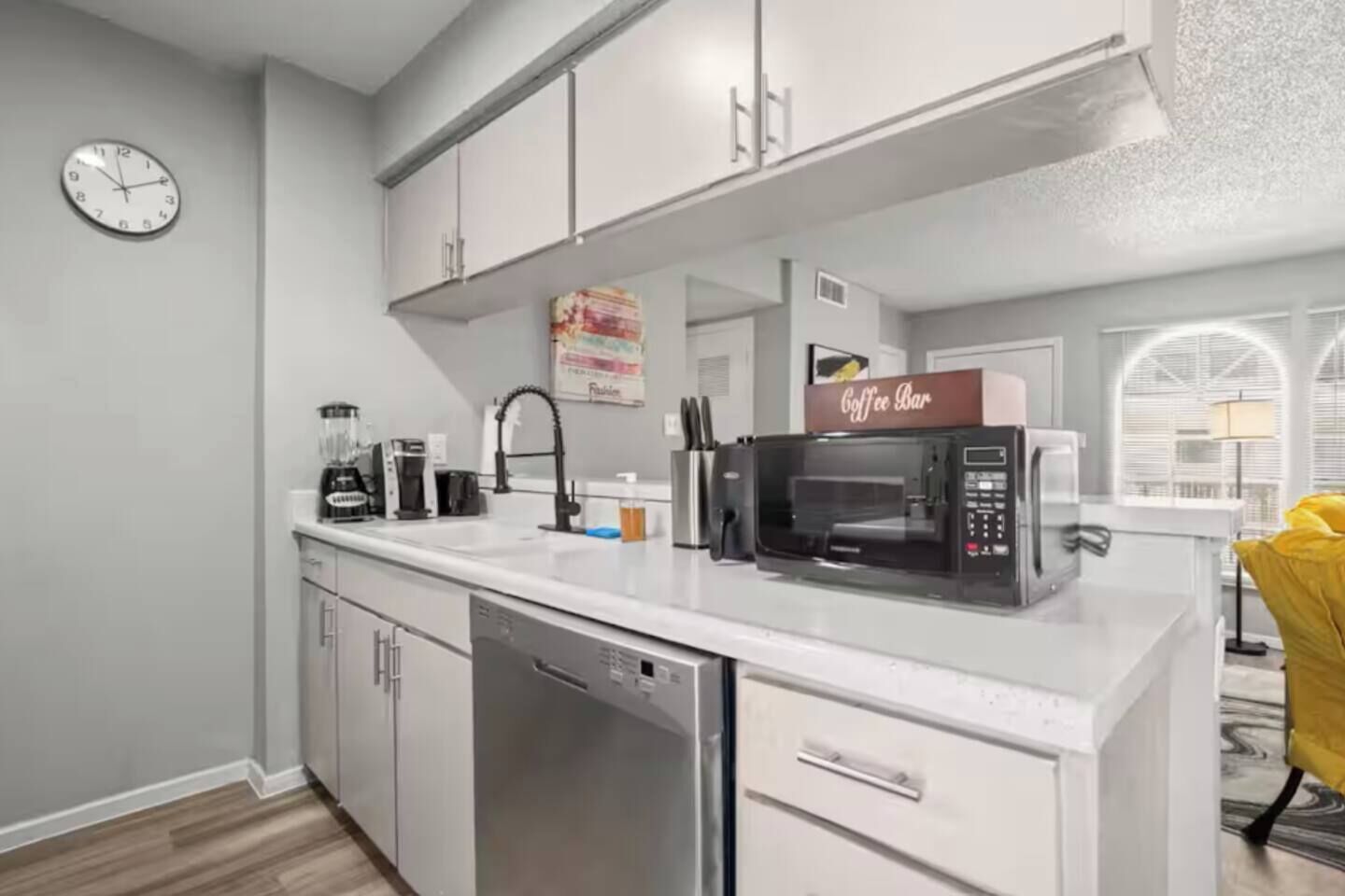A modern kitchen with a dishwasher, a coffee maker, and a microwave.