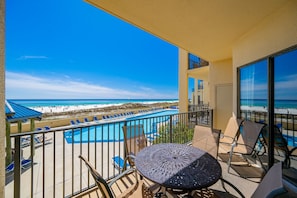 Ein Balkon mit Blick auf Strand und Pool.