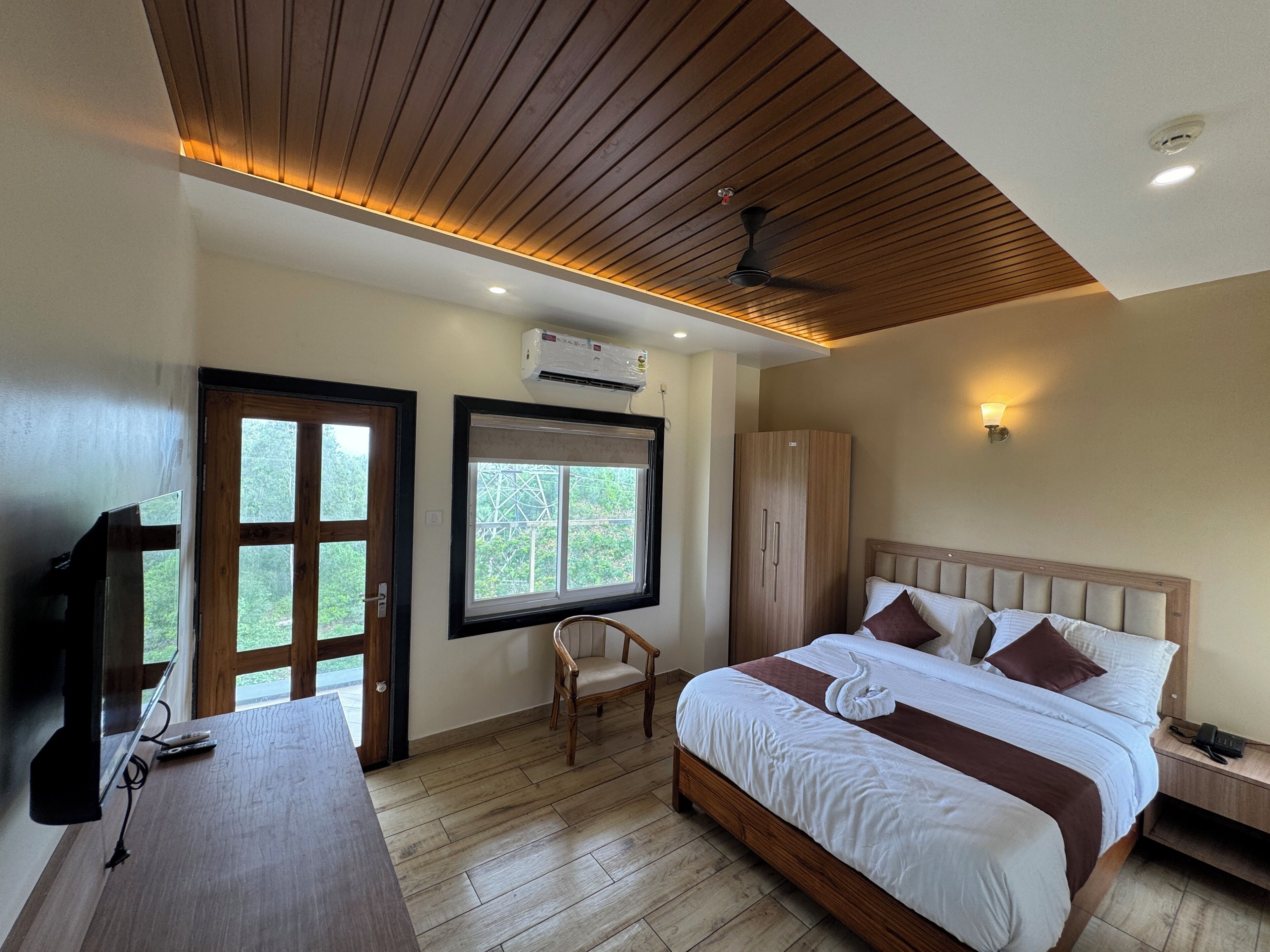 Une chambre d’hôtel équipée d’un lit, d’un bureau, d’une armoire, d’une fenêtre et d’un appareil de climatisation.