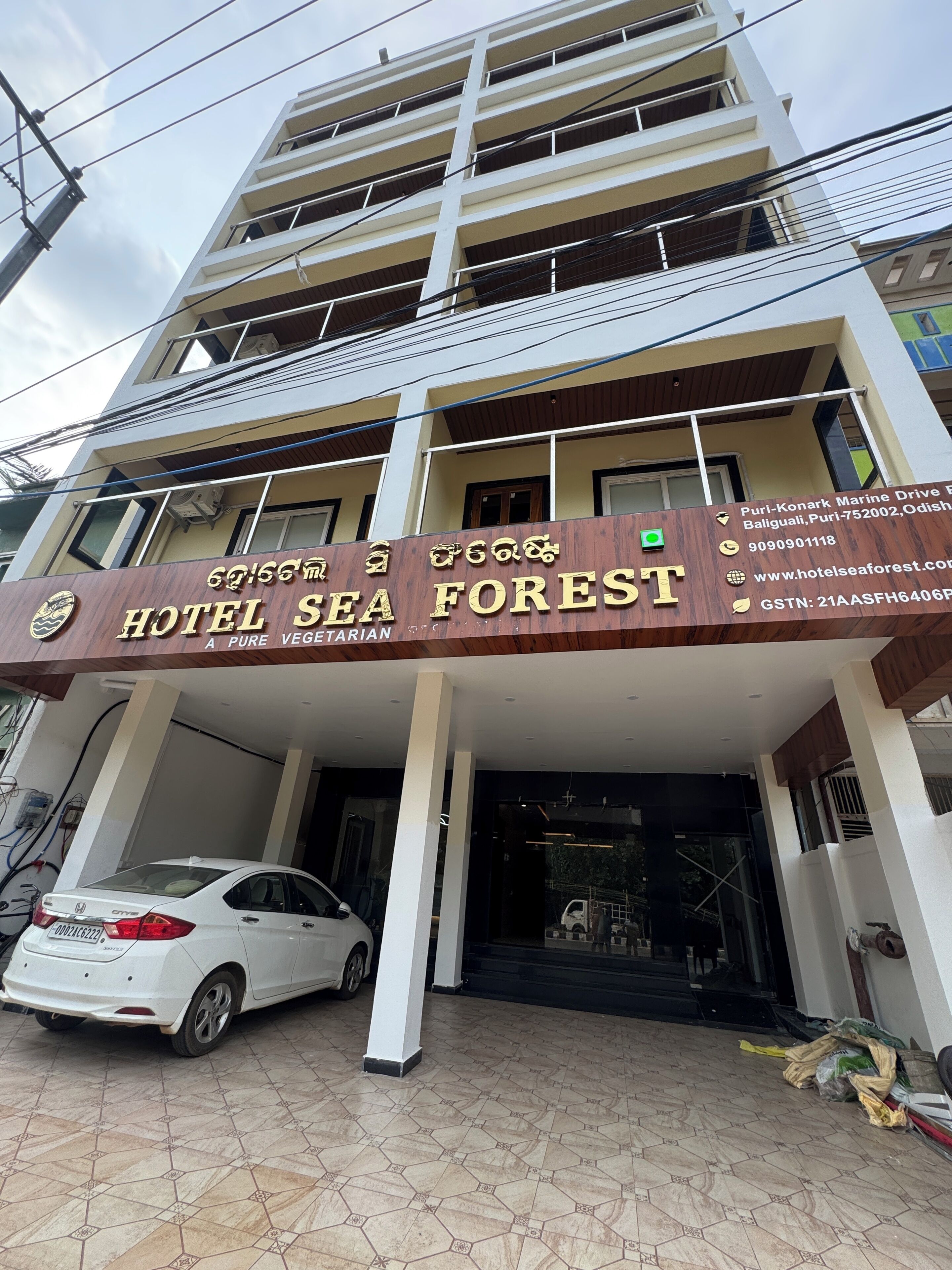 A multi-story building with a sign for 'Hotel Sea Forest' indicating a vegetarian restaurant.