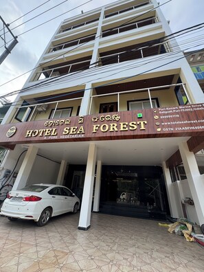 A multi-story building with a sign for 'Hotel Sea Forest' indicating a vegetarian restaurant. - Hotel Sea Forest (Puri)