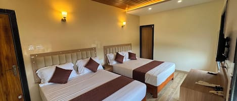 A hotel room with two beds, a wooden ceiling, and a TV on a wooden stand.