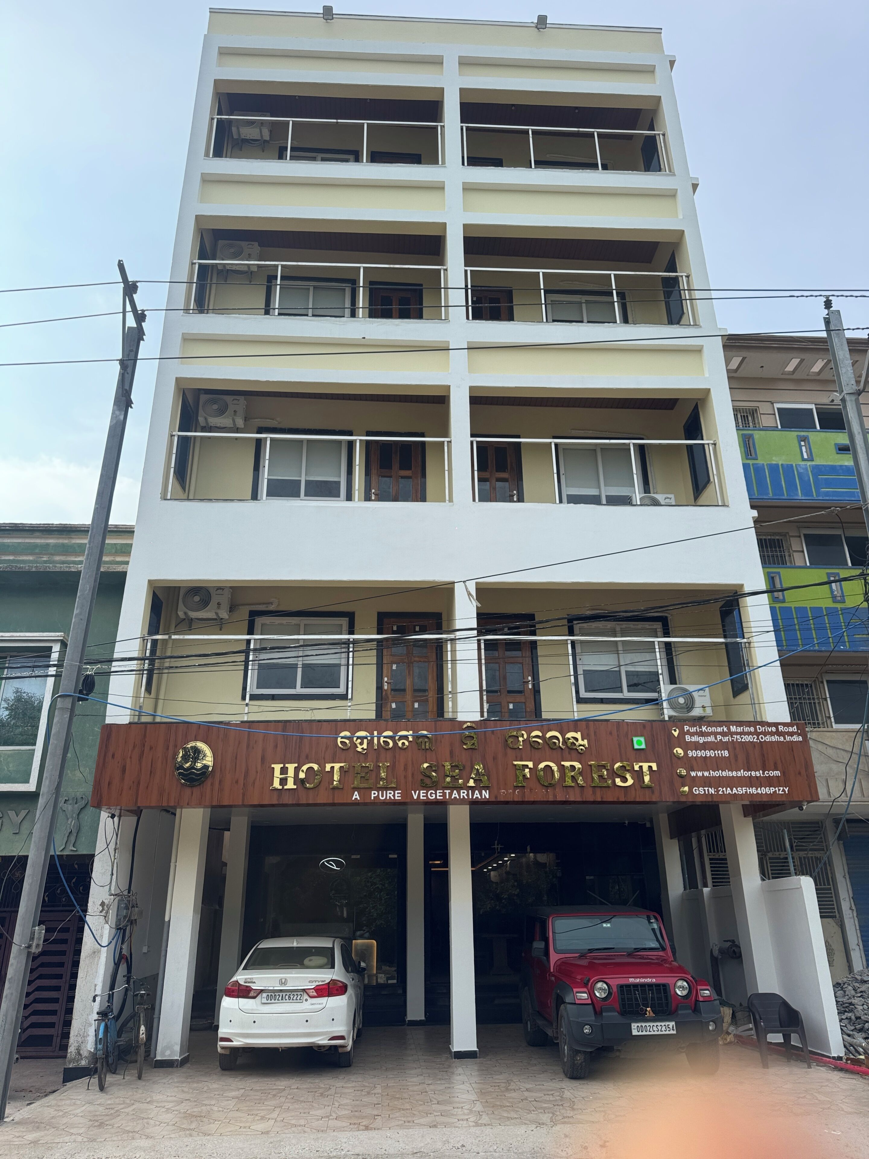 A multi-story building with a sign for 'HOTEL SEA FOREST' indicating it is a vegetarian hotel.