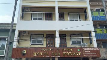 A multi-story building with a sign for 'HOTEL SEA FOREST' indicating it is a vegetarian hotel.