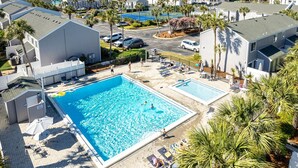 Ett hotell med ett stort poolområde, flera pooler och utsikt över havet.
