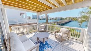A covered outdoor deck with a view of a waterfront and a bridge. - South Bay By The Gulf 054 2 Bedroom Townhouse (Destin)