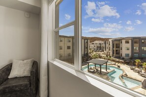 A room with a view of a swimming pool and adjacent buildings. - Adventure Loft 3 Bedroom Condo (Hurricane)