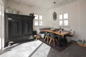 Une cuisine moderne avec une table à manger en bois, des chaises noires et un meuble sombre.