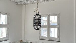 A dining area with a wooden table, black chairs, and a black hanging light fixture. - Holiday Home 'Casa Opala Townhouse with Pool' , Wi-Fi and Air Conditioning (Olhão)