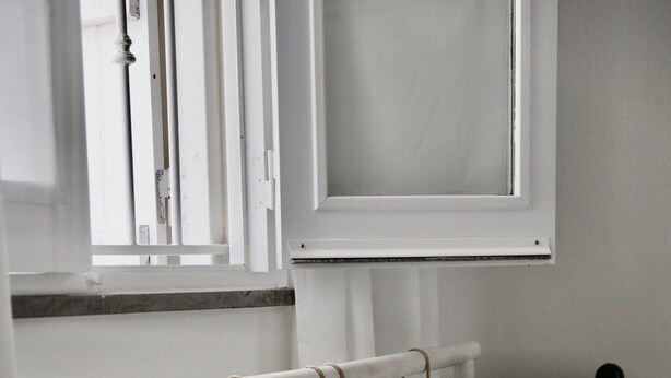 A bed with white bedding, a window with blinds, and a radiator. - Holiday Home 'Casa Opala Townhouse with Pool' , Wi-Fi and Air Conditioning (Olhão)