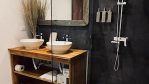 Une salle de bain moderne avec un meuble-lavabo en bois, deux vasques, un grand miroir et une douche.