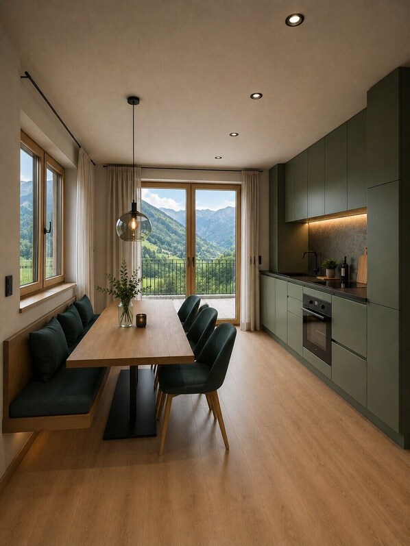 Une cuisine moderne avec un coin repas, de grandes fenêtres et une vue sur les montagnes.