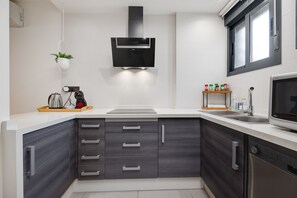 Eine moderne Küche mit eingebautem Geschirrspüler, einer Mikrowelle und einer Kaffeemaschine auf der Arbeitsplatte.