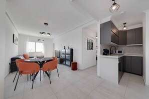 A modern kitchen with dark cabinets and a white countertop. - CB Living - Seaview penhouse in Cabo Roig (Orihuela)