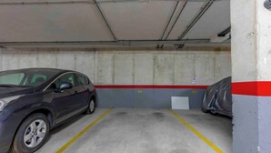 A parking garage with a car parked in a space marked with yellow lines. - CB Living - 3 bedroom home in Punta Prima (Alicante / Alacant)