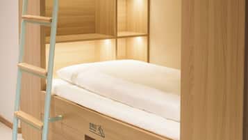 Una cama litera con escalera, un espacio para guardar zapatos y una pequeña estantería.
