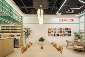 A modern bar area with a neon sign, a long table with chairs, and a wall with framed pictures. - Shanghai Zhuxiaoman Urban Hostel (Shanghai)