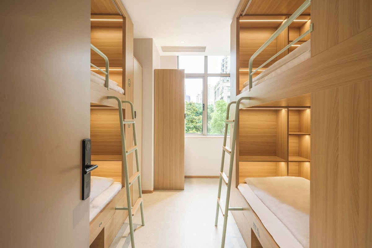 A compact room with bunk beds, a window, and a door.