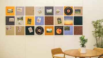 Una pared con una cuadrícula de paneles cuadrados, algunos con fotografías y uno con un disco de vinilo.
