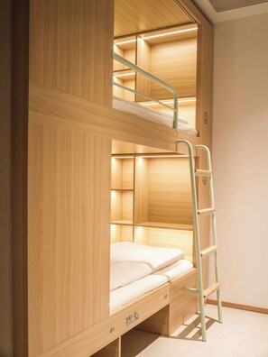 Uma cama beliche com escada, paredes de madeira e o número '02' na lateral.