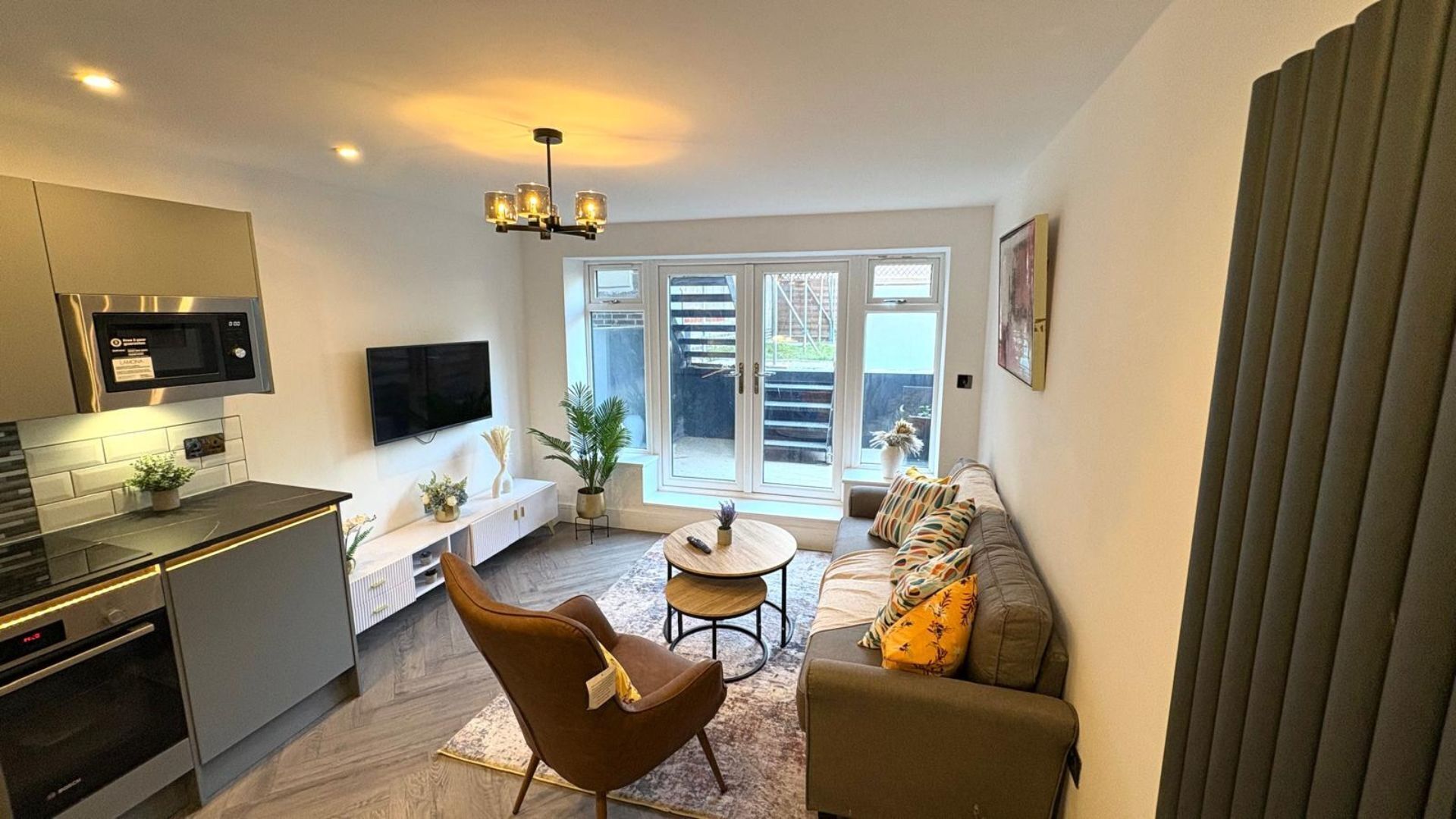 A modern living space with a kitchen, dining area, and seating area.