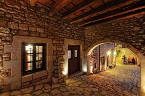 Ein Steinhaus mit einem Kopfsteinpflasterhof, Holzbalken und Rundbogenportalen.