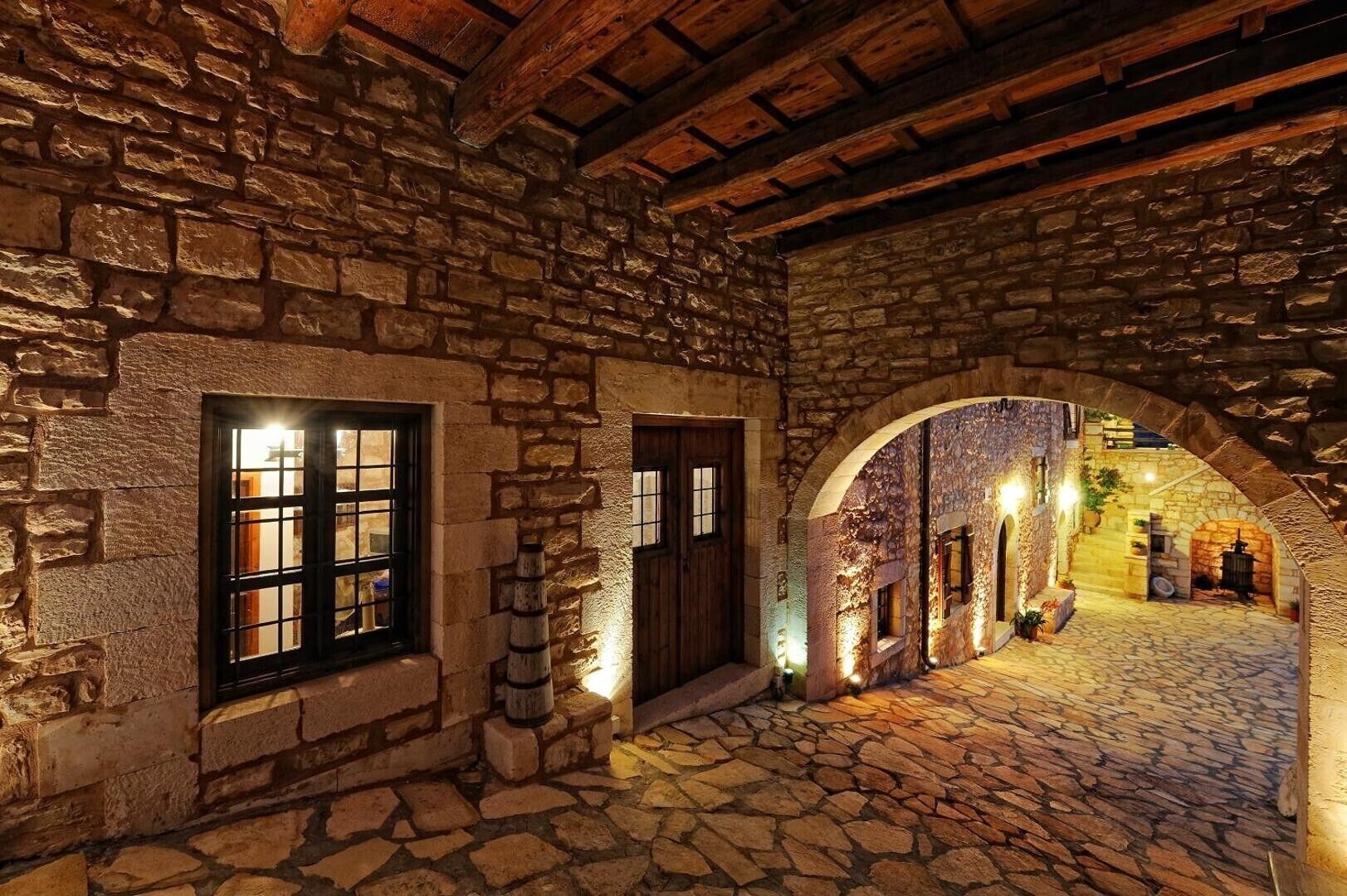 A stone building with a cobblestone courtyard, wooden beams, and a rustic atmosphere.