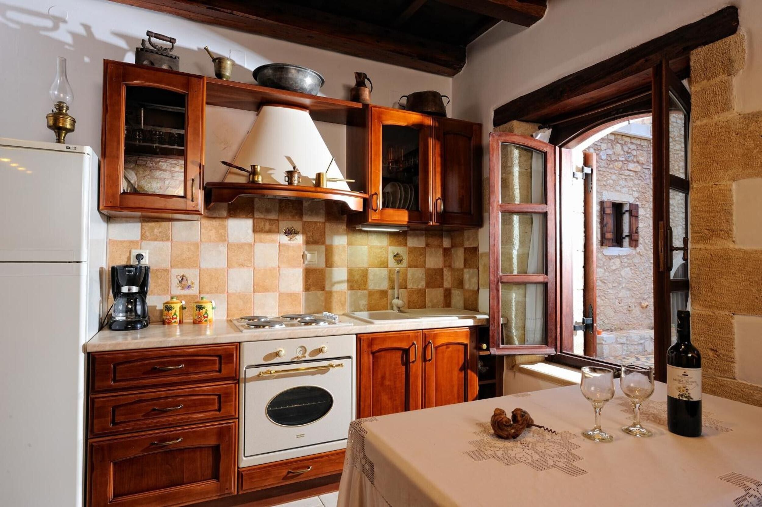A kitchen with wooden cabinets, a stove, and a window with a view of the outside.