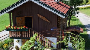 Un edificio de madera con techo rojo, un porche de madera y un cartel que dice 'FISCHERHUTTE'.