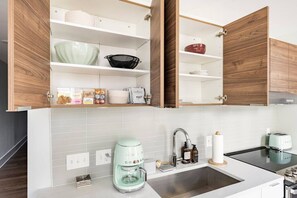 A modern kitchen with white cabinets, a built-in oven, a coffee maker, and a toaster. - Centrally Located, Free Garage Parking! (Cincinnati)