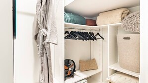 Ein Schrank mit Regalen, Kleiderstange und einer Aufbewahrungsbox.