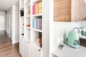 A modern kitchen with a teal coffee maker and white cabinetry. - Centrally Located, Free Garage Parking! (Cincinnati)