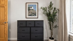 A room with a wooden door, a black filing cabinet, a framed picture on the wall, and a potted plant. - Lux Historic 2BR near Stadiums, Downtown (Cincinnati)