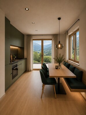 Une cuisine moderne avec un coin repas, de grandes fenêtres et une vue sur l’extérieur.