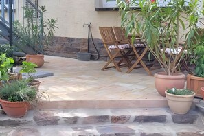 A patio with a seating area, potted plants, and a stone wall. - Pet-friendly apartment 'Linus' (Geisenheim)