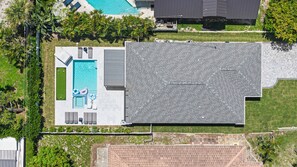 An aerial view of a residential property with a swimming pool, a covered patio area, and a large roofed deck. - Brand New - Gorgeous 3 Bedroom 3 Bathroom (Naples)