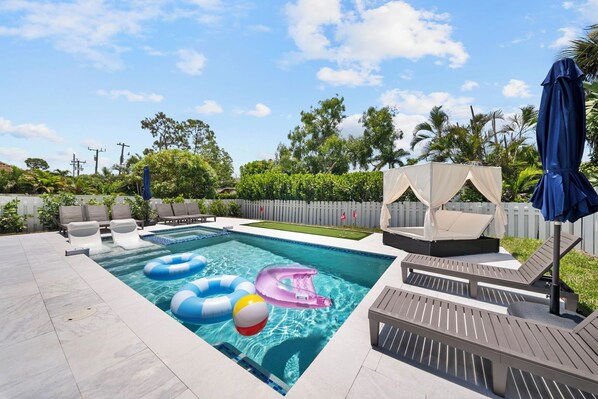 A swimming pool with lounge chairs and inflatable toys. - Brand New - Gorgeous 3 Bedroom 3 Bathroom (Naples)